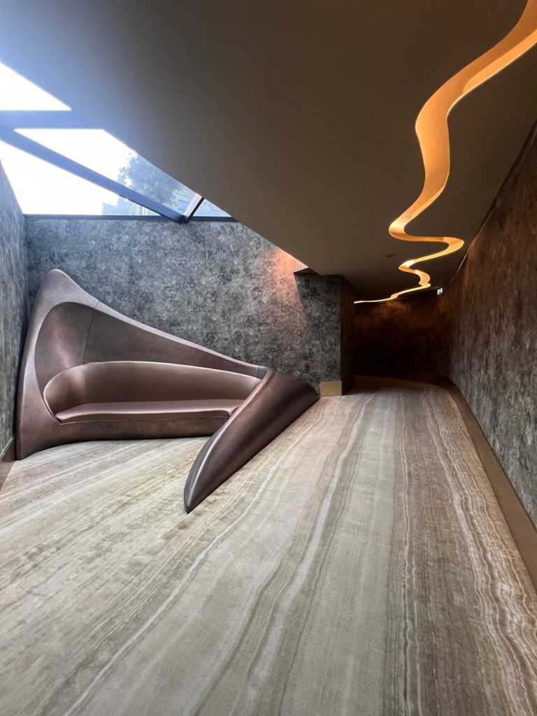 Photo of a modern artwork displayed inside Vila Foz Hotel and Spa. The piece features sleek, contemporary design elements, with clean lines and a minimalist aesthetic. Set against a backdrop of the hotel's luxurious interior, which includes elegant lighting, neutral-toned walls, and sophisticated decor, the artwork complements the serene and upscale ambiance of the space.